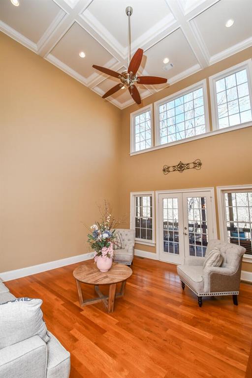 interior space with french doors, coffered ceiling, baseboards, and wood finished floors