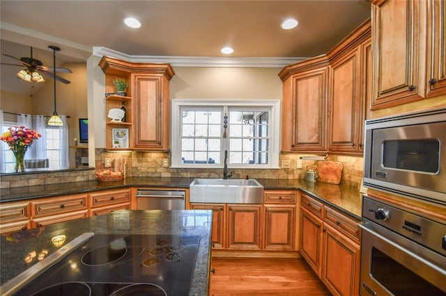 kitchen featuring appliances with stainless steel finishes, brown cabinetry, a sink, and backsplash