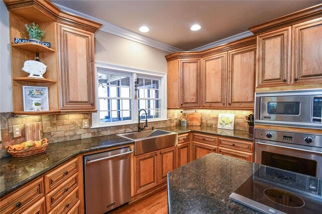 kitchen featuring appliances with stainless steel finishes, a sink, backsplash, and open shelves