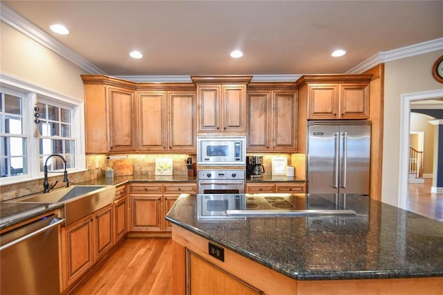 kitchen featuring brown cabinets, crown molding, and built in appliances