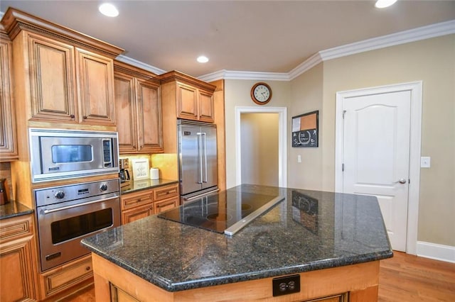 kitchen featuring crown molding, recessed lighting, light wood-style floors, a kitchen island, and built in appliances