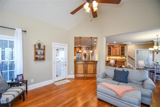 living room featuring stairs, a healthy amount of sunlight, baseboards, and light wood-style floors