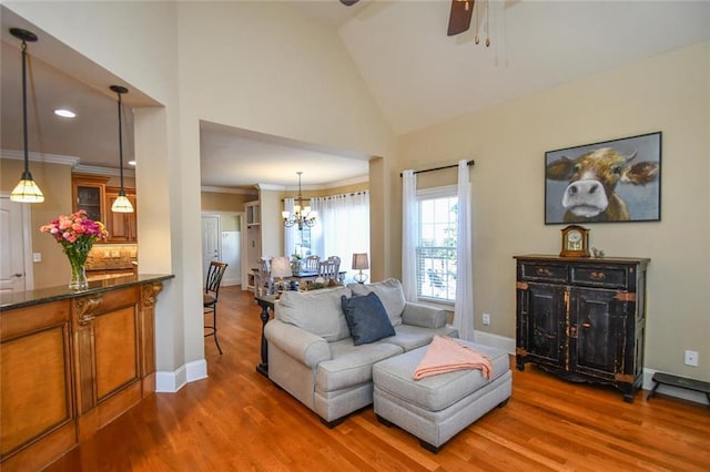 living area featuring crown molding, baseboards, and wood finished floors