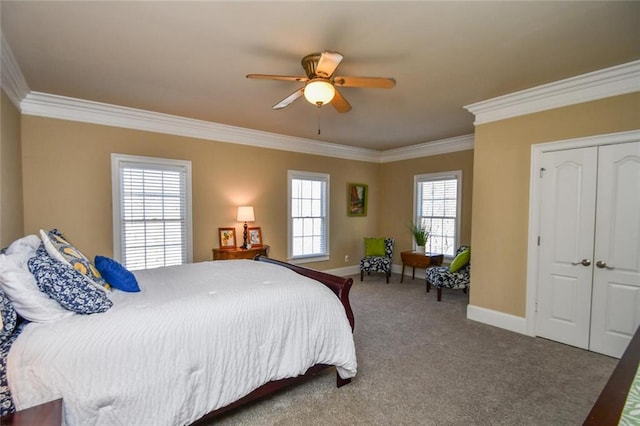 carpeted bedroom featuring a ceiling fan, a closet, baseboards, and crown molding