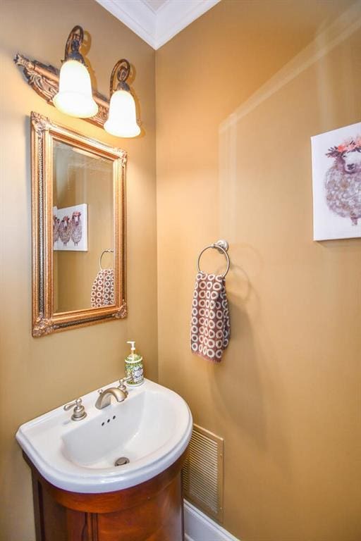 bathroom featuring visible vents, a sink, and ornamental molding