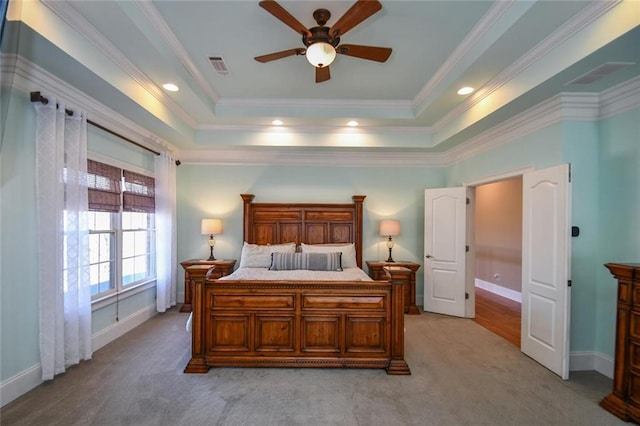 bedroom with a raised ceiling, light carpet, and crown molding