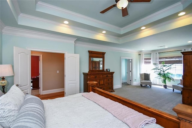 carpeted bedroom with baseboards, a ceiling fan, ornamental molding, a tray ceiling, and recessed lighting