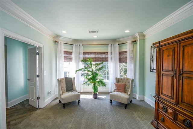 sitting room featuring baseboards, carpet floors, visible vents, and crown molding