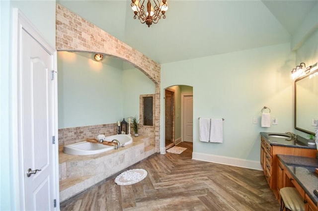 bathroom featuring baseboards, a garden tub, vanity, a shower stall, and a chandelier