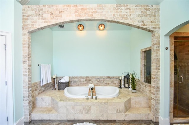 bathroom featuring visible vents, a garden tub, and a shower stall