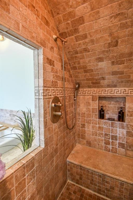 full bath with lofted ceiling and tiled shower