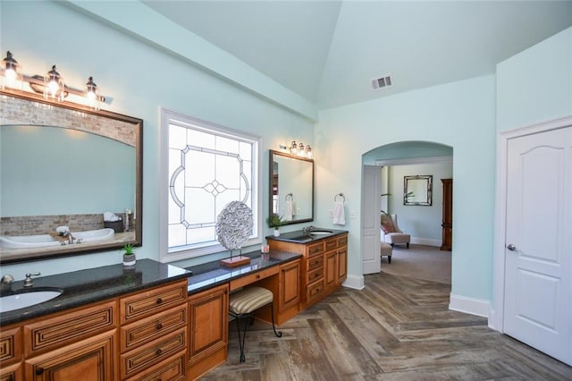 full bathroom with visible vents, vaulted ceiling, vanity, and baseboards