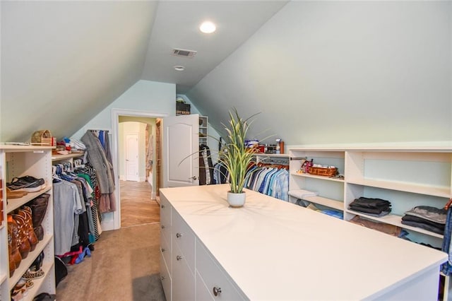 spacious closet featuring lofted ceiling, visible vents, and light carpet