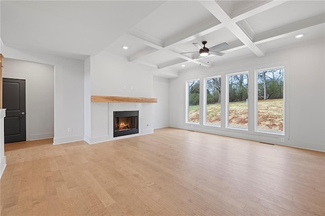 unfurnished living room with beamed ceiling, light wood finished floors, coffered ceiling, recessed lighting, and baseboards