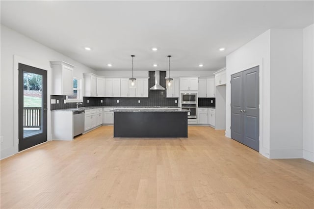 kitchen with stainless steel appliances, wall chimney exhaust hood, backsplash, recessed lighting, and white cabinetry
