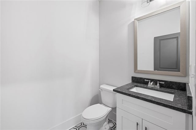 bathroom featuring toilet, vanity, baseboards, and tile patterned flooring