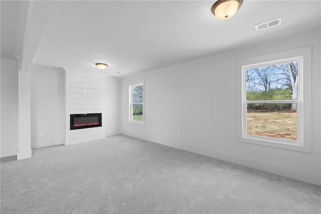 unfurnished living room featuring carpet, a fireplace, and baseboards