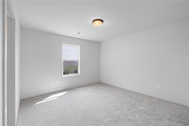 spare room featuring carpet flooring and baseboards