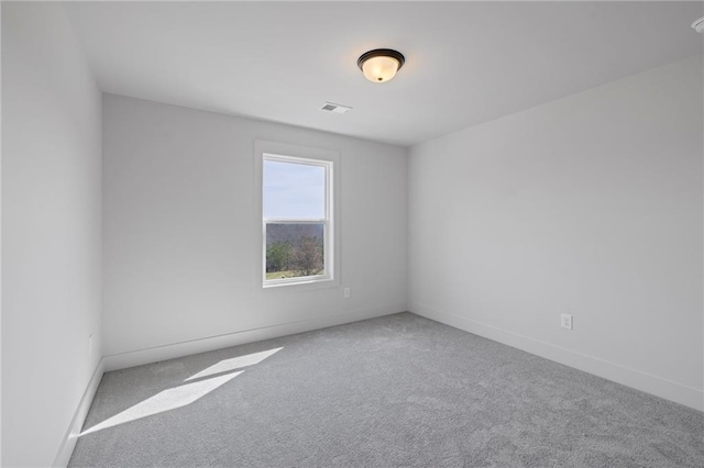 spare room with carpet and baseboards