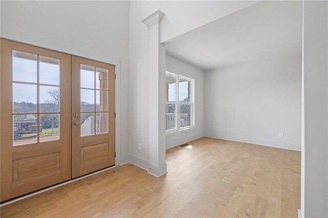 entryway with light wood-type flooring, french doors, and baseboards