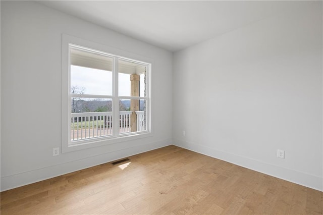 spare room with light wood-style floors and baseboards