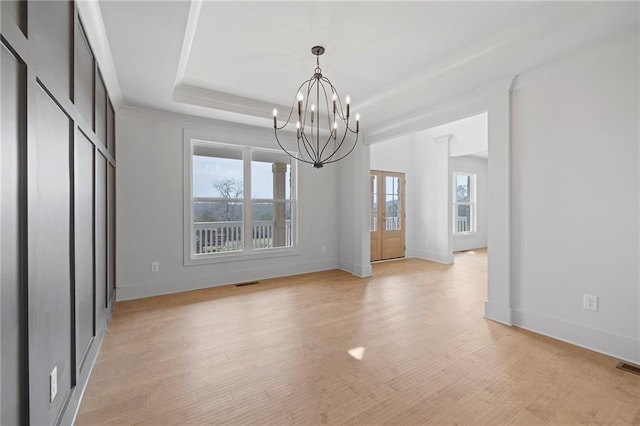 unfurnished dining area featuring plenty of natural light, a chandelier, baseboards, and light wood-style flooring