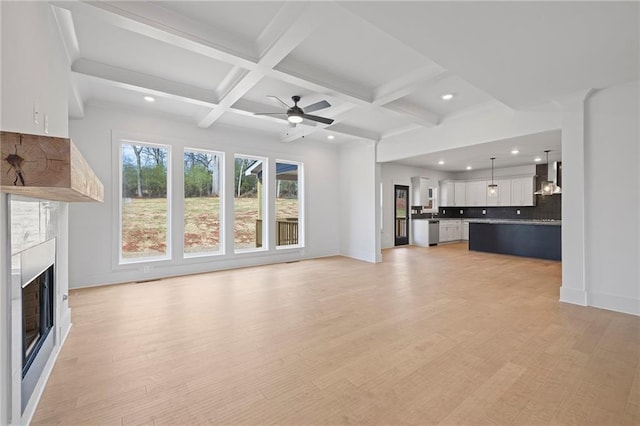 unfurnished living room featuring a fireplace, coffered ceiling, recessed lighting, beam ceiling, and ceiling fan