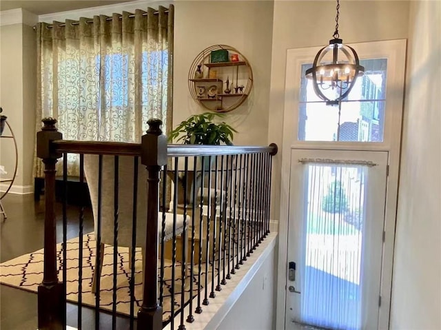 doorway with hardwood / wood-style flooring, plenty of natural light, and a chandelier