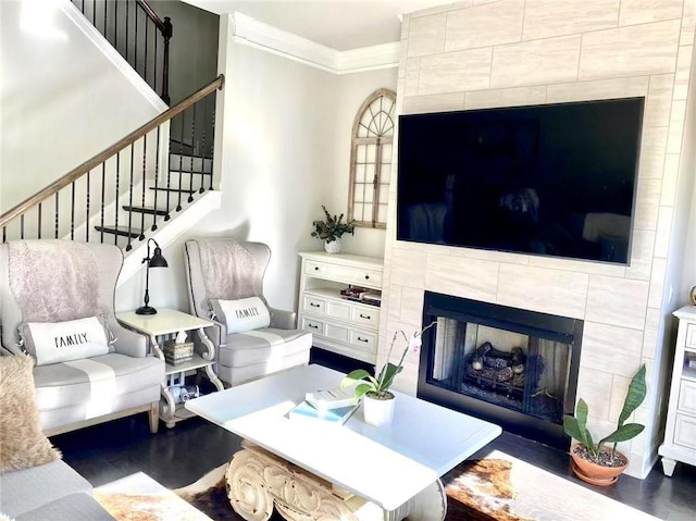 living room featuring crown molding, a fireplace, and dark hardwood / wood-style floors