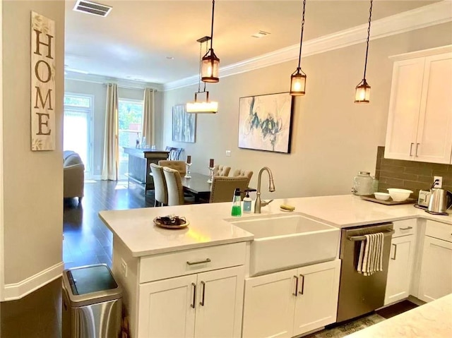 kitchen featuring white cabinetry, stainless steel dishwasher, decorative light fixtures, and sink