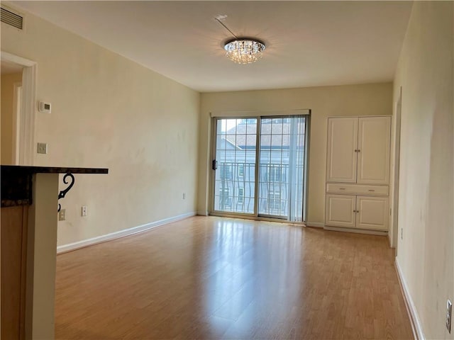 199 14th St NE Unit 710, Atlanta, GA 30309 - unfurnished room with light wood finished floors and a chandelier
