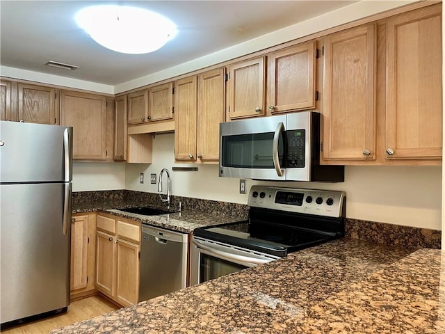 199 14th St NE Unit 710, Atlanta, GA 30309 - kitchen featuring appliances with stainless steel finishes, dark stone countertops, and light wood-type flooring
