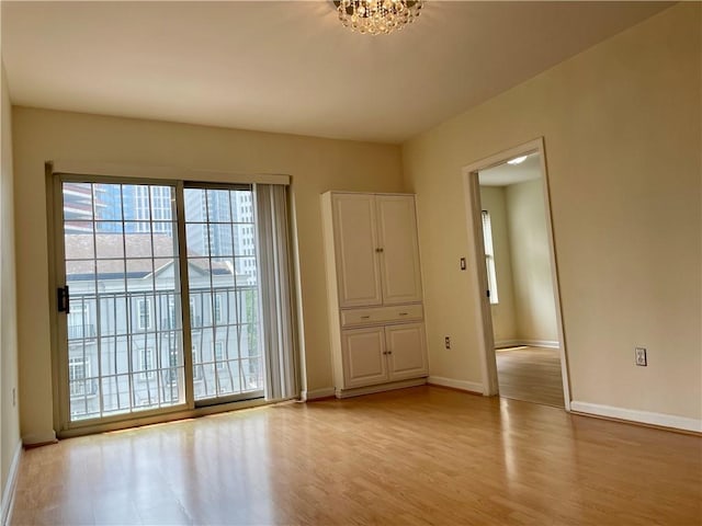 199 14th St NE Unit 710, Atlanta, GA 30309 - unfurnished room featuring light wood-style floors and a chandelier