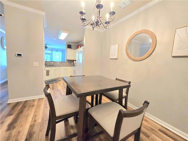 1975 Nocturne Dr Unit 2206, Alpharetta, GA 30009 - dining room with crown molding, a chandelier, and light wood-type flooring