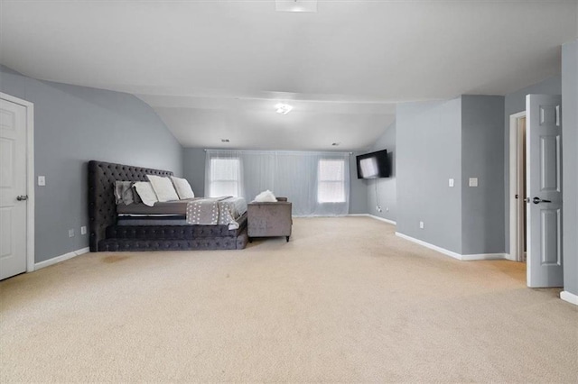 carpeted bedroom featuring baseboards and lofted ceiling