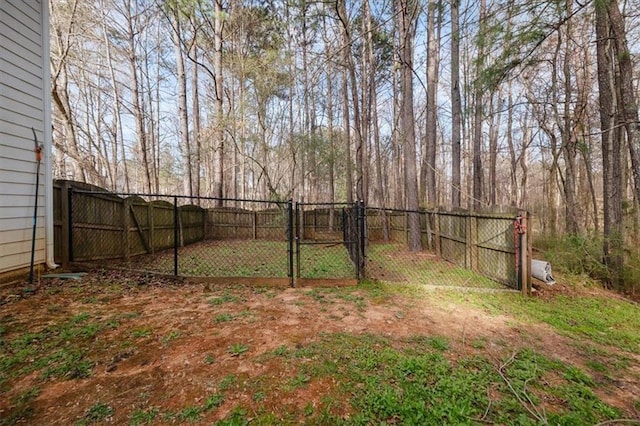 view of yard with a fenced backyard and a gate