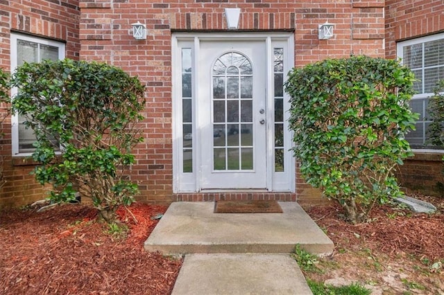 view of exterior entry with brick siding