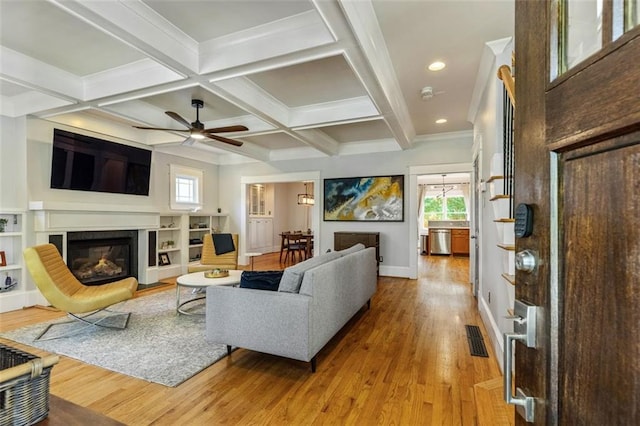 891 Paoli Ave SE, Atlanta, GA 30316 - living area featuring light wood-type flooring, healthy amount of natural light, a glass covered fireplace, beam ceiling, and a ceiling fan