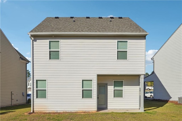 rear view of property with a lawn and central air condition unit