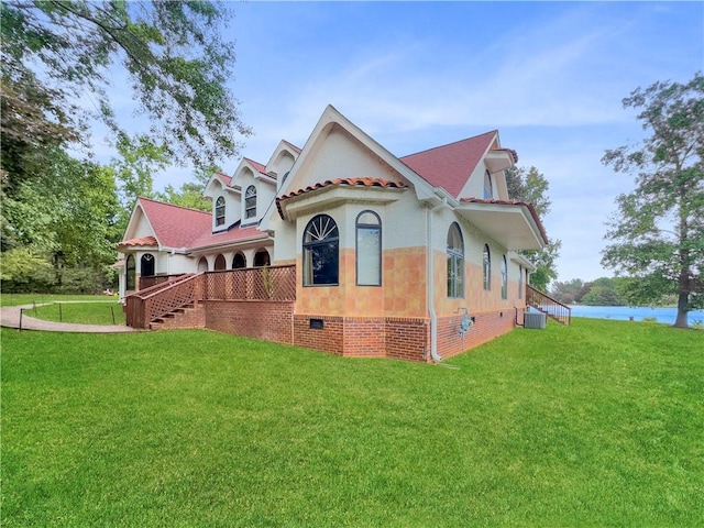 view of front of house with central AC and a front yard