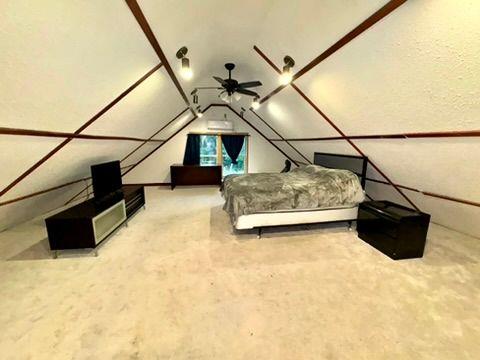 bedroom featuring lofted ceiling and carpet