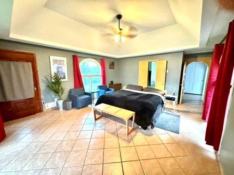 bedroom featuring light tile patterned flooring and a tray ceiling