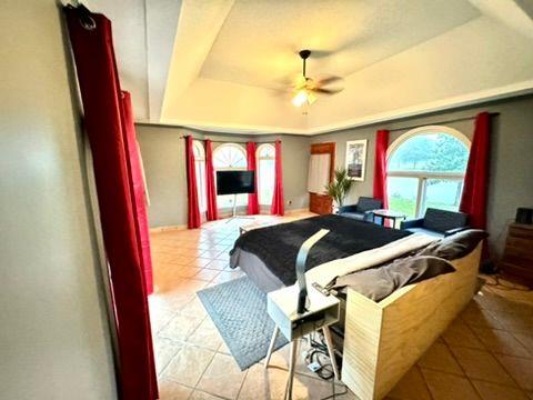 bedroom with a raised ceiling and light tile patterned floors