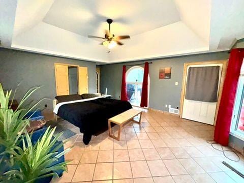 bedroom with a raised ceiling and light tile patterned floors