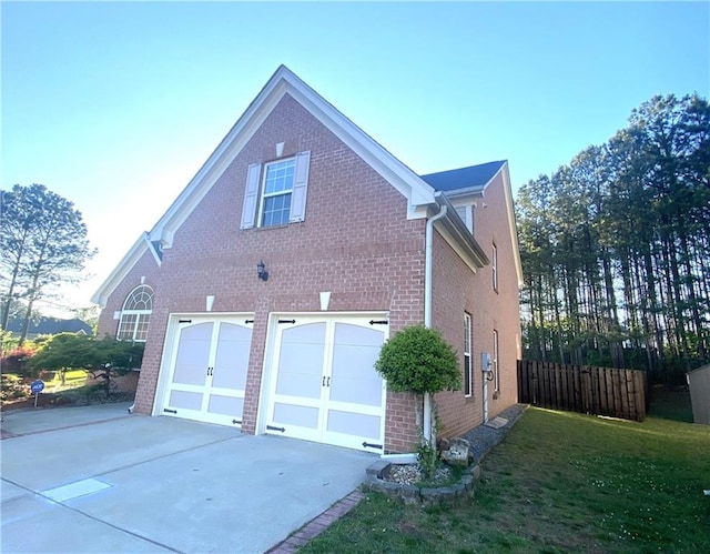 view of side of property featuring a garage and a lawn