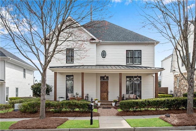 view of front of home with a standing seam roof, a porch, and metal roof