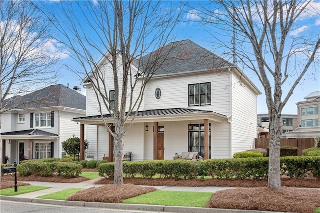 view of front of house featuring fence and covered porch