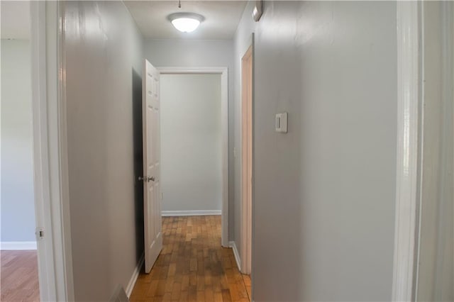 corridor with hardwood / wood-style flooring