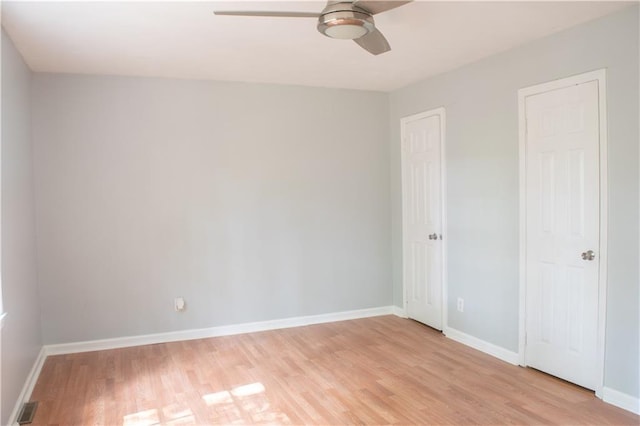 unfurnished bedroom with multiple closets, light wood-type flooring, and ceiling fan