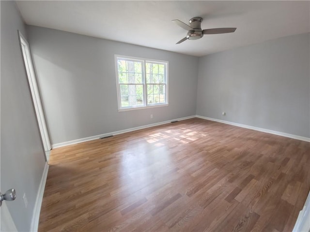 empty room with hardwood / wood-style flooring and ceiling fan